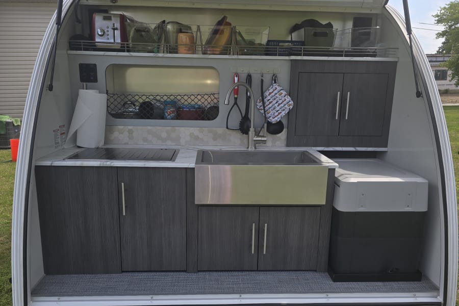 Kitchen with 2 burners, Cooler frig, and sink. Small kitchen gadgets, Wine opener. 