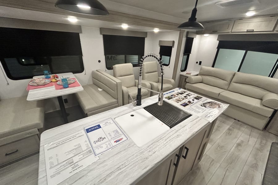Spacious RV interior with modern kitchen, dining, and living areas, ideal for your next rv rental.