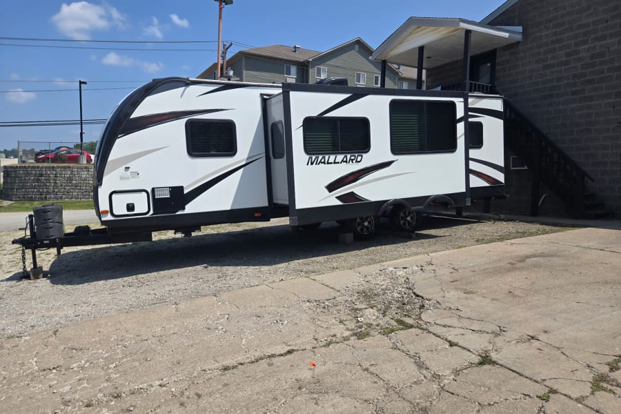 White Mallard travel trailer parked on a sunny lot, ideal for your next rv rental adventure.