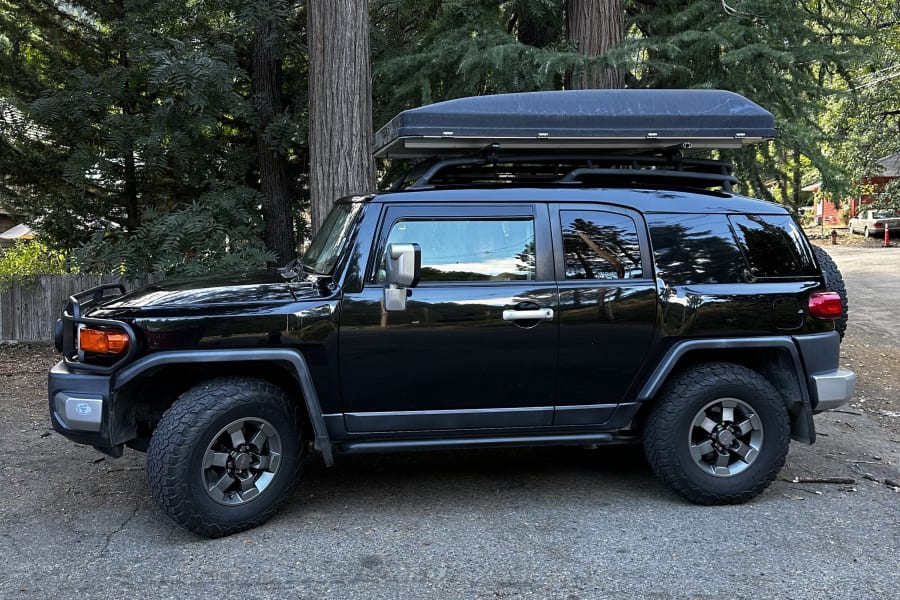 Black FJ Cruiser with rooftop tent, a versatile **RV rental** option for outdoor adventures and camping.