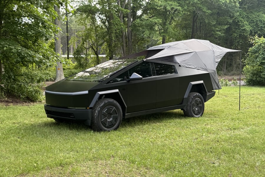 Tesla Cybertruck with a pop-up tent camper, perfect for an rv rental adventure in nature.