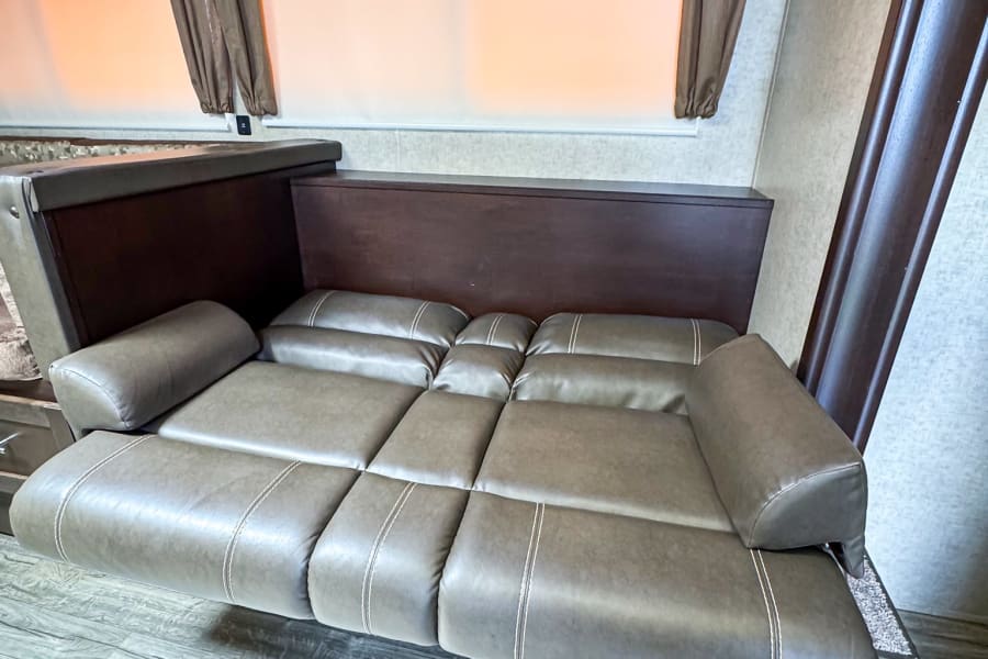 Comfortable reclining sofa inside a modern RV rental, ideal for relaxing during your travels.