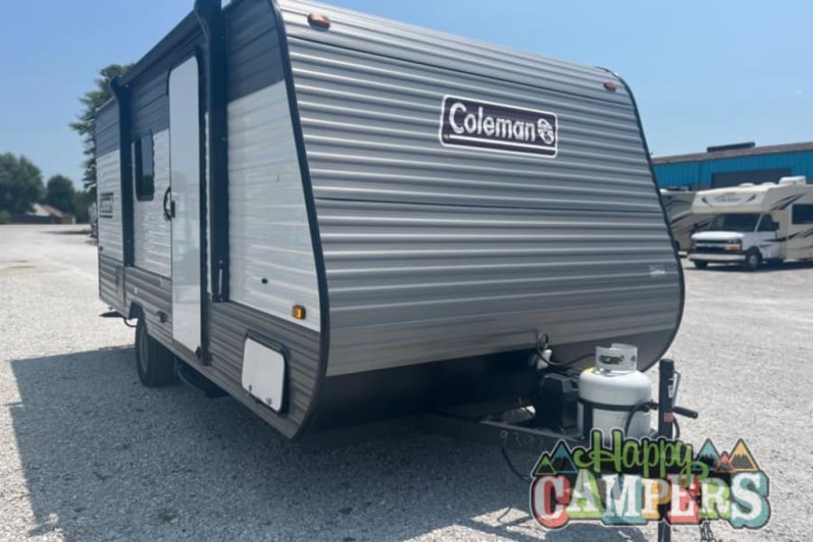Coleman travel trailer RV rental, grey and white with a propane tank, ready for your camping adventure.