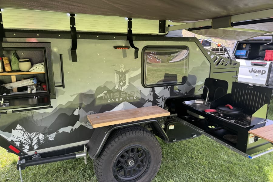 Mission Overland trailer's outdoor kitchen. Sink, stove, and counter space for camping or an RV rental. Ready for adventure!