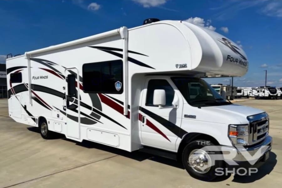 White Thor Four Winds Class C RV for rent, featuring bold graphics. Ideal motorhome for your next adventure.