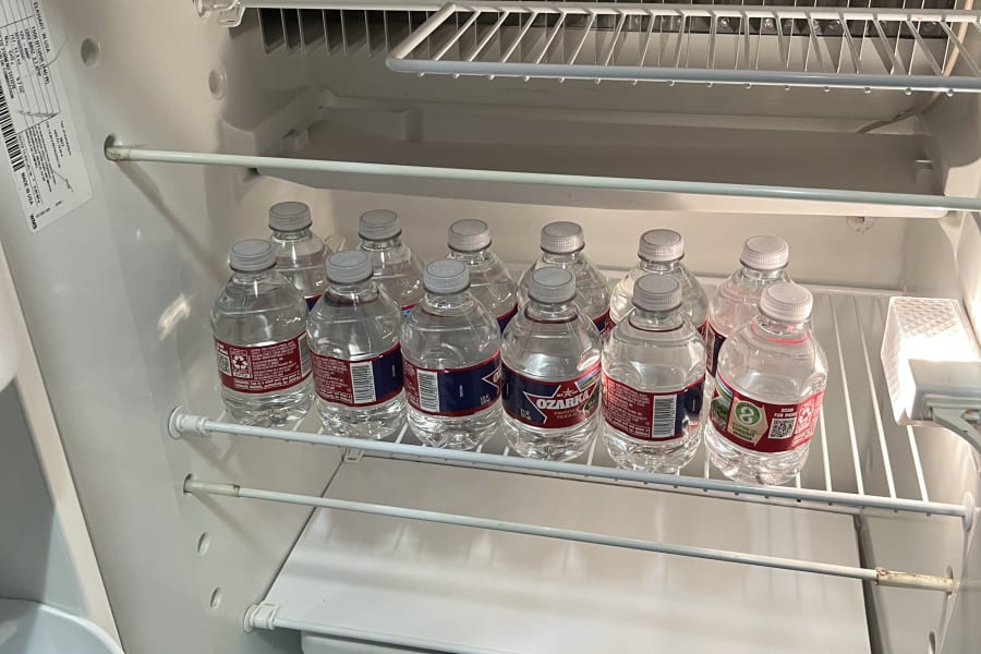 View inside an RV rental refrigerator: multiple Ozarka water bottles on a shelf, with a "Made in U.S.A." label at the bottom.
