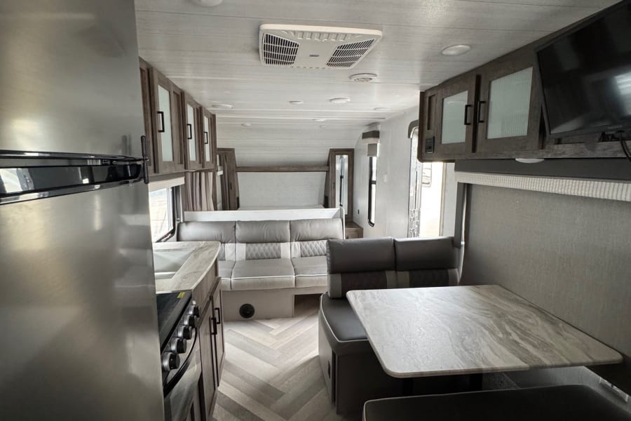 Spacious rv rental interior: modern kitchen, comfortable dinette, and inviting living/bedroom zones.