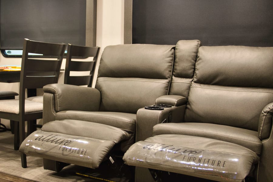 Relax in this RV rental! Modern gray recliners by Allure Furniture, with cup holders & protective footrests.