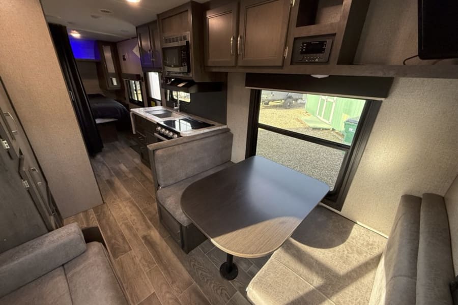 Spacious RV rental interior with modern kitchen, dinette, sofa, and bedroom. Ideal for comfortable travel and accommodations.