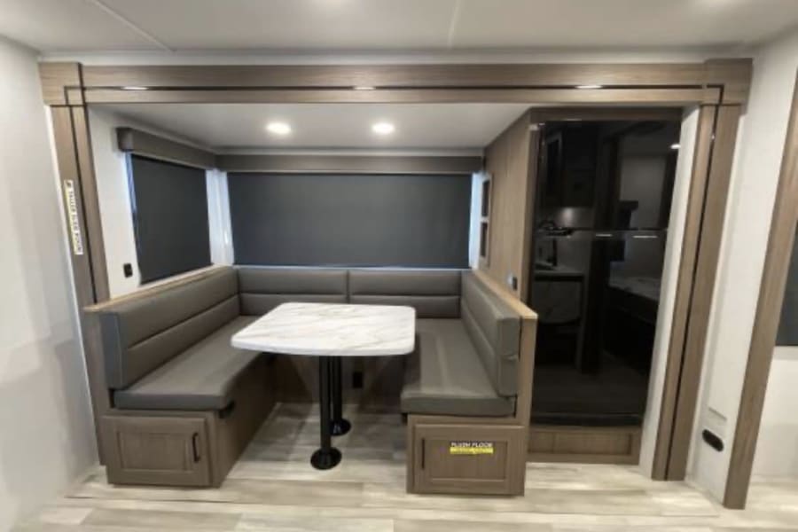 U shaped dining area for the family or friends' group to gather and eat, play games. Then, it can also become a place to sleep as the dining table goes down to make a flat place to rest!