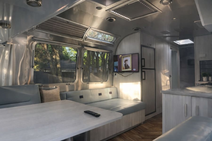 Experience comfort in this rv rental. Features a bright, modern interior with dinette, TV, and kitchen amenities.