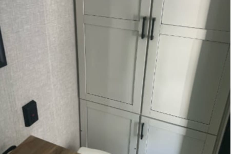 RV rental bathroom featuring a sink, toilet, and built-in storage cabinets, typical of a Starcraft Autumn Ridge travel trailer.