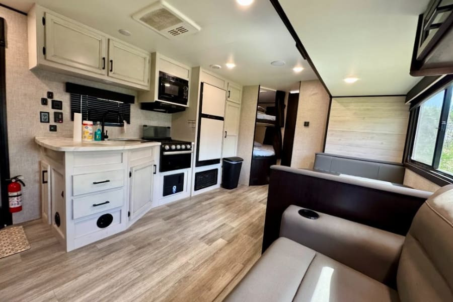 Spacious RV rental interior with modern kitchen, living area, and bunk beds. Perfect for family adventures.