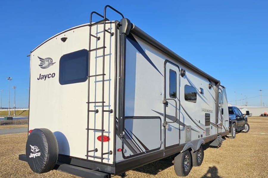 Explore in style with this Jayco travel trailer rv rental, featuring a rear ladder & spare tire cover, ready for adventure.