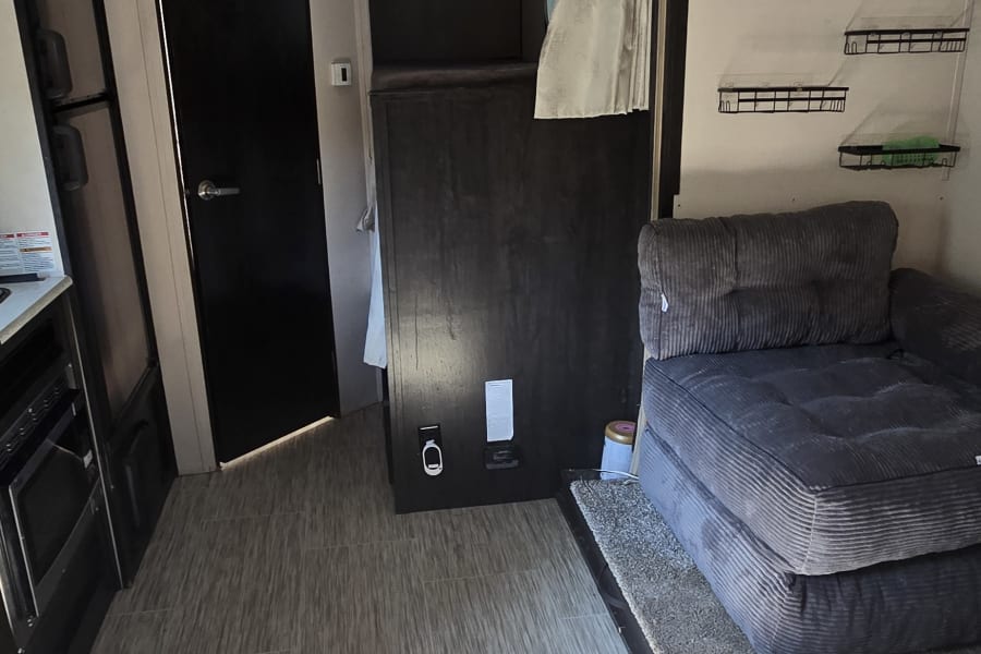 Bright RV rental interior showing living space, kitchen area, bunk beds, and comfy seating. Perfect for your next adventure.