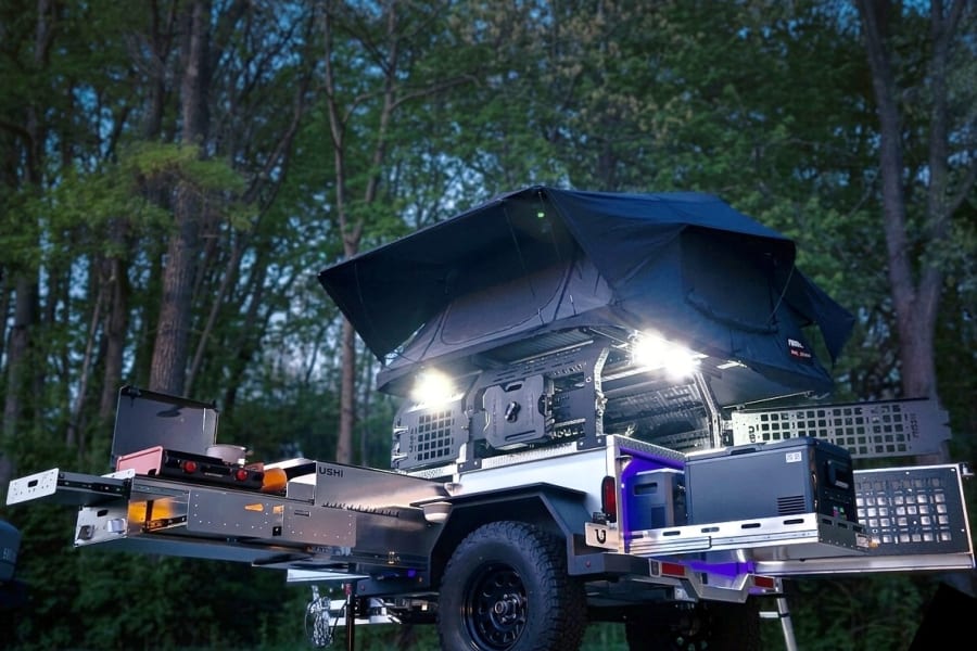 Compact rv rental trailer with rooftop tent, slide-out kitchen, and storage. Ideal for off-grid camping adventures.