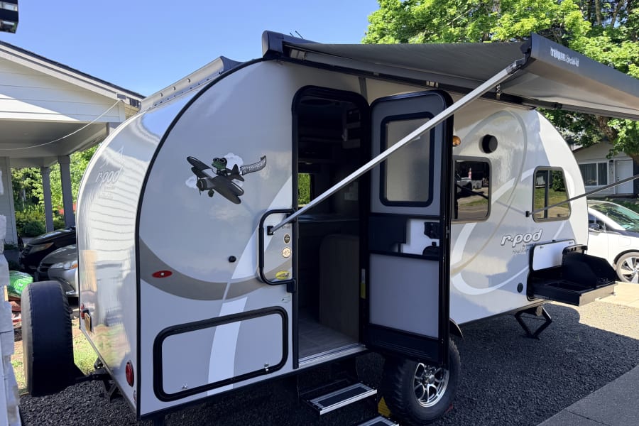 Forest River r-pod travel trailer, a great rv rental, with an extended awning, outdoor kitchen, and 10th-anniversary decal.