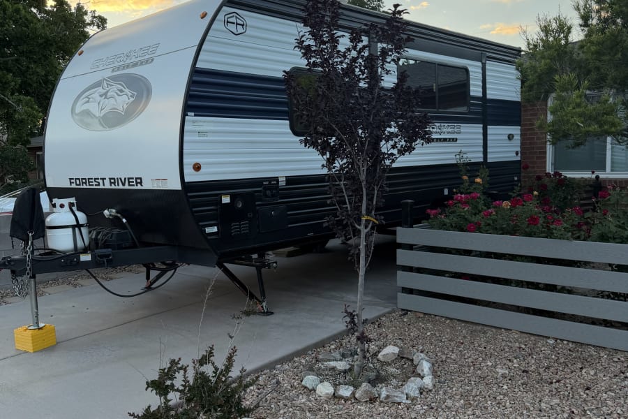 White & black Forest River Wolf Pup travel trailer, perfect for your next rv rental, under a warm, cloudy sunset.