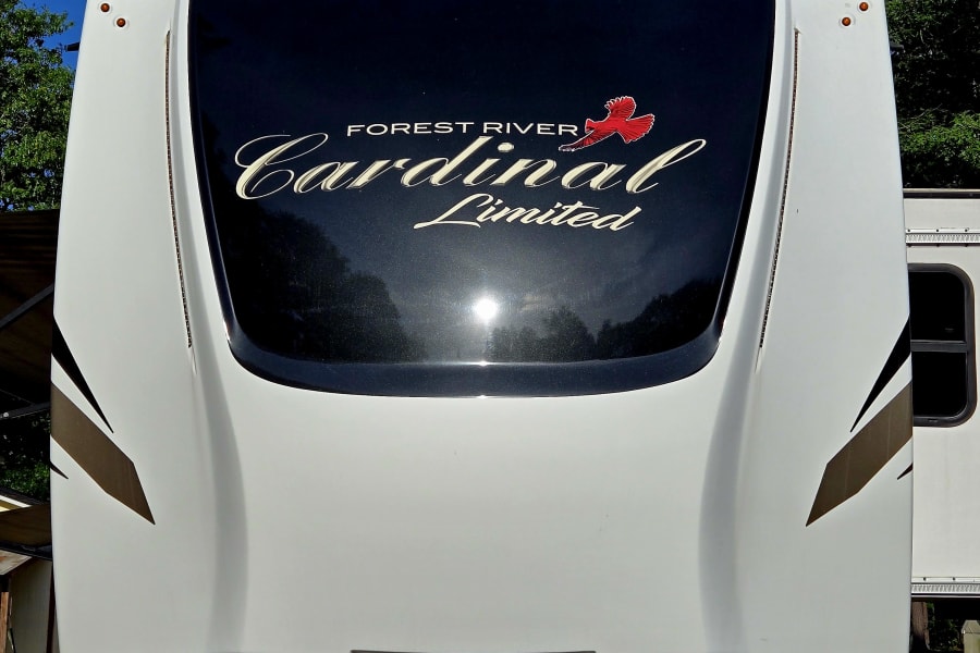 Sleek front of a white and black Forest River Cardinal Limited fifth-wheel RV, perfect for your rv rental getaway!