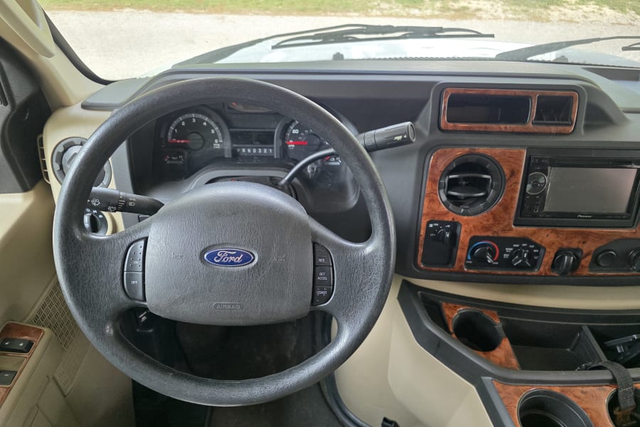 A Ford RV rental interior: dashboard with steering wheel, instruments, climate controls, and Pioneer stereo setup.