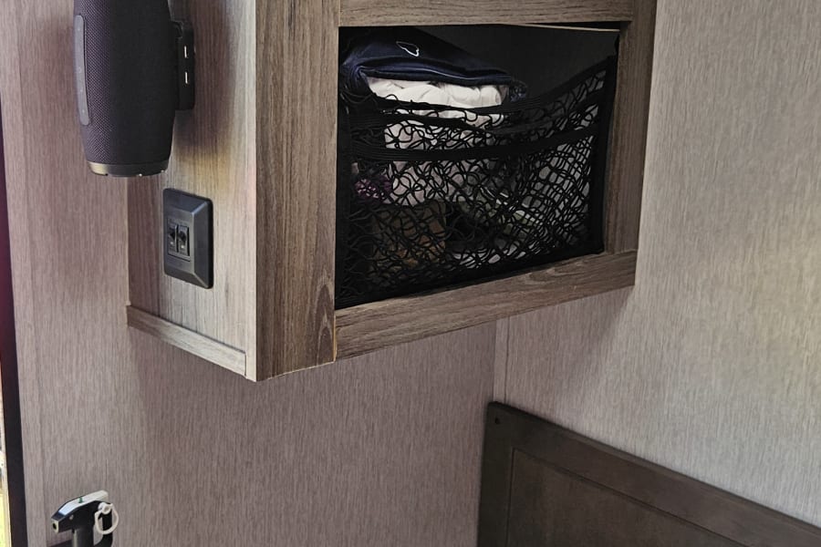 Practical RV rental interior: features include AC, speaker, storage net, and fire extinguisher for a safe, comfortable trip.