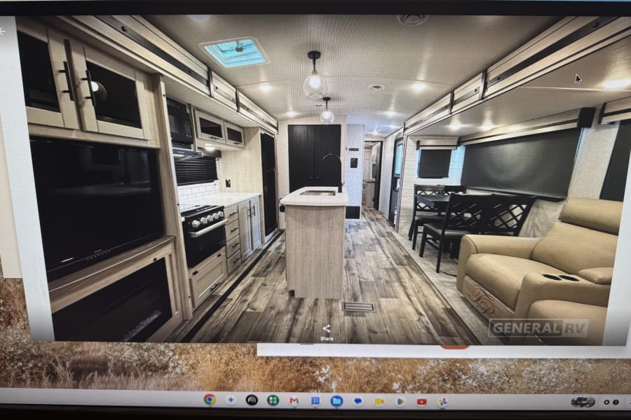 Spacious RV rental interior featuring a modern kitchen with island, dining area, and cozy recliner seating.