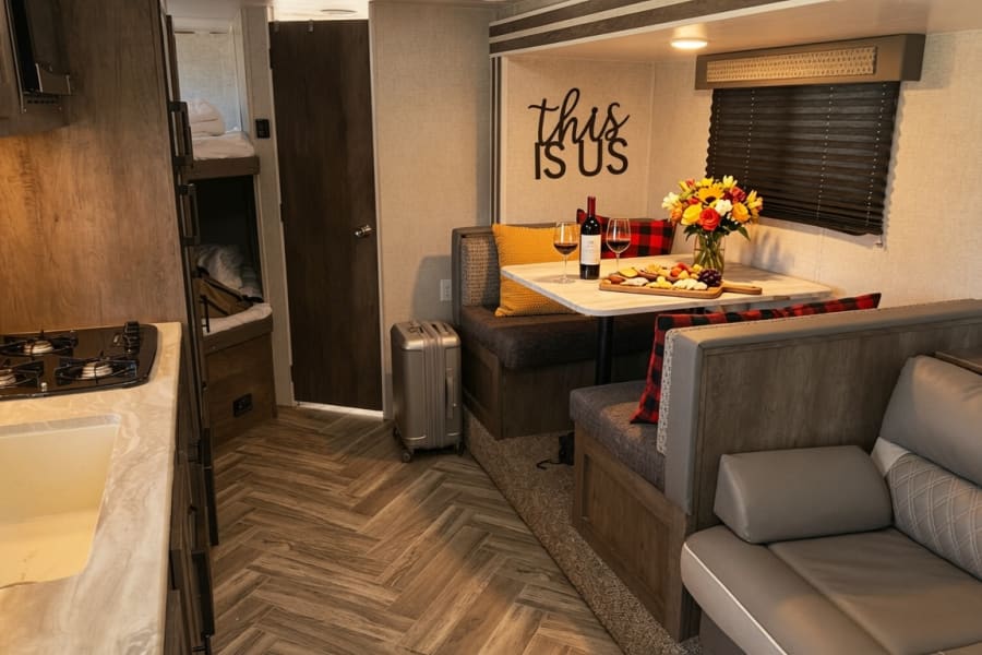 RV rental interior featuring a kitchen, dinette with wine/cheese, bunk beds, and lounge area. A comfy space for travel.