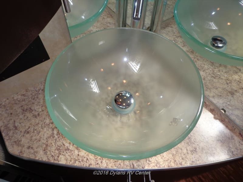 Stylish amenities throughout such as the glass sink and LED lighting it accents are also functional allowing for more storage space by the sink etc. 