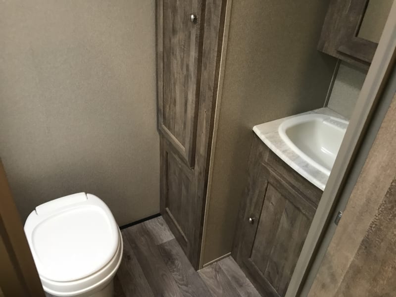 private washroom with a sink, toilet and stand up shower