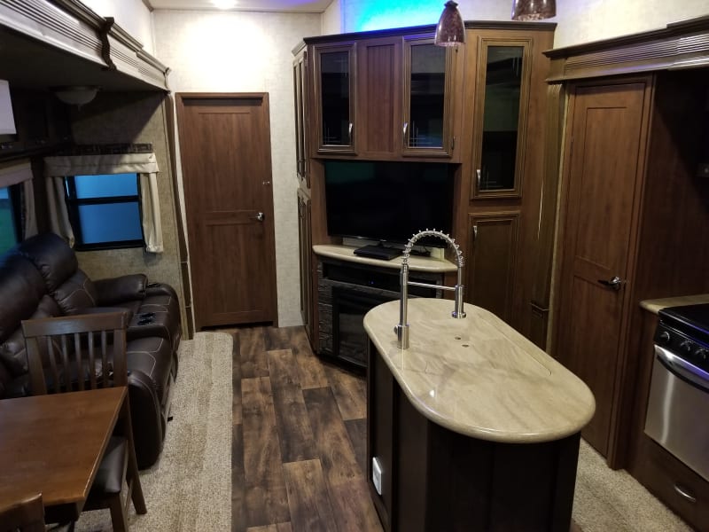 Main cabin area with 2 reclining leather chairs that also massage and heat up. Tv, dining room set and kitchen area with granite counter tops. 