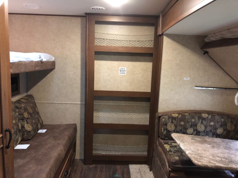 Two upper bunks, a booth style table (folds down to a bed) and a lounge/bunk.