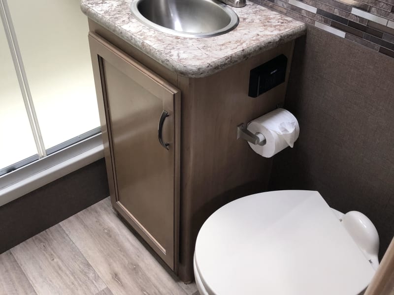 Bathroom sink / cabinet with Porcelain flush toilet / sliding shower door. Includes RV toilet paper and Citrus drop in toilet treatment bags! 