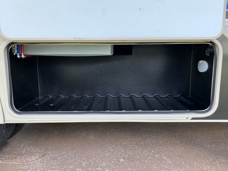 This compartment is 52w 21h 20d just behind the entry door on the passenger side. It will be left empty for your storage.