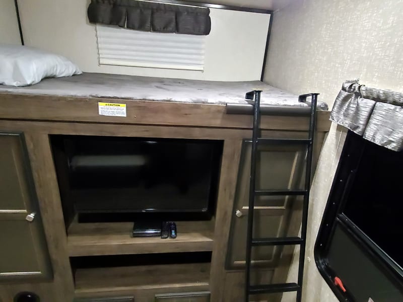 Twin-sized bunk (300 lb capacity) is much larger than the other side.  Entertainment center with closet space & 32