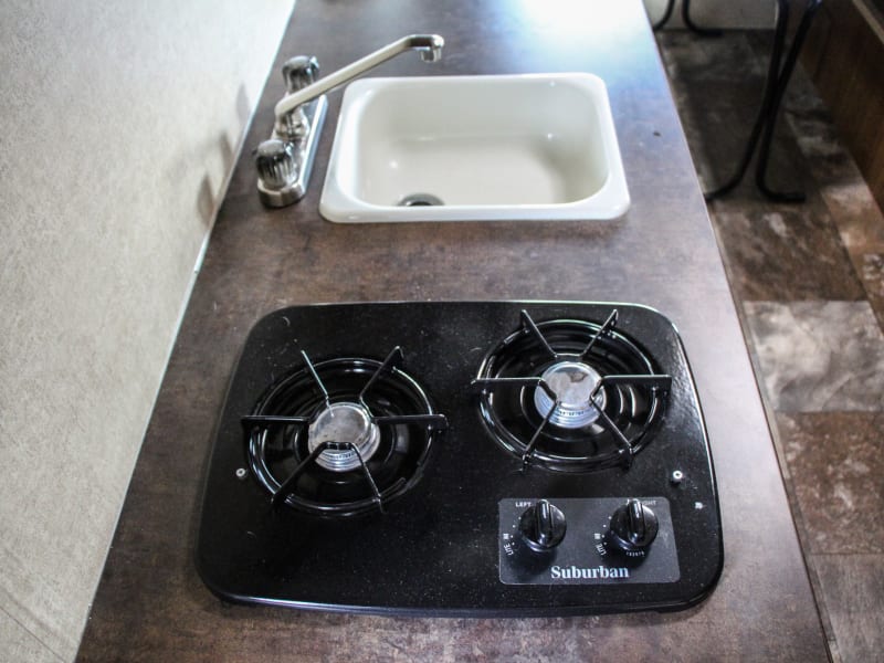 2 burner propane stove and sink with hot and cold water.