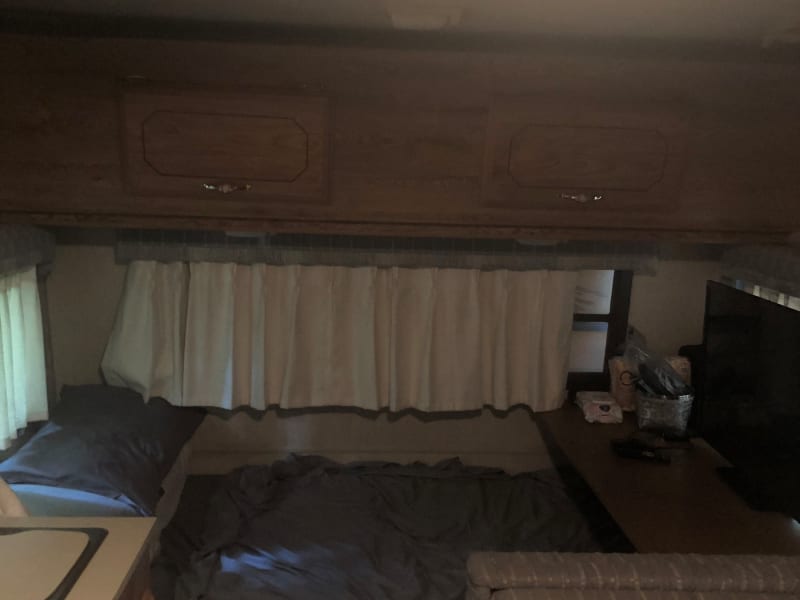 Cough pulls out to a full bed. Above bed is a fold out loft/bunk suitable for a child to sleep on. Privacy curtain not pictured but great feature!