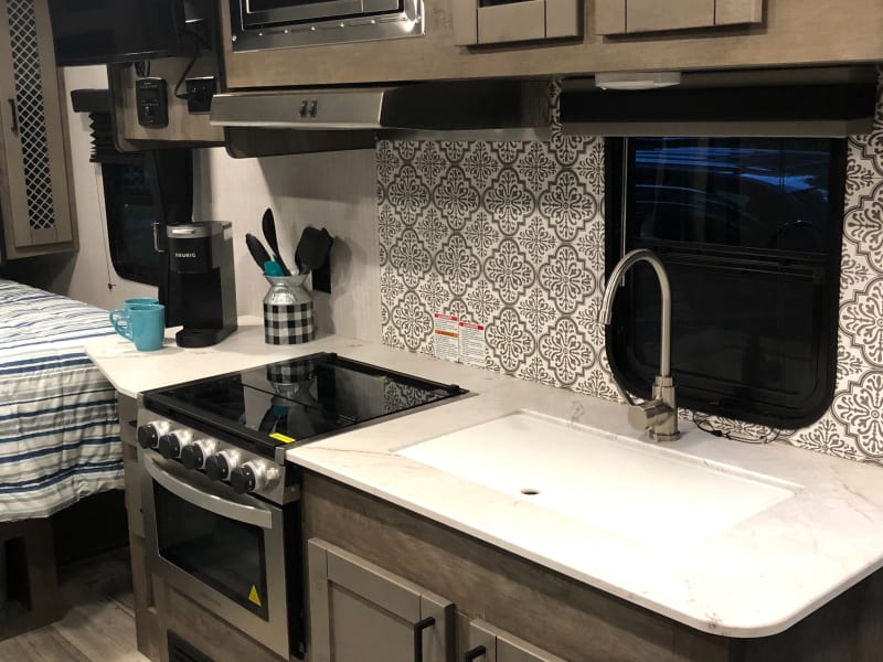 Deep sink, plenty of cabinets, 3 burner stove, propane oven 