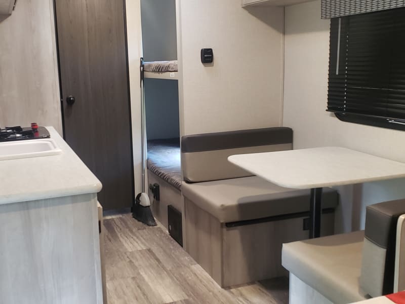 Serve meals at the small but functional dinette from the kitchen featuring sink, two-burner stove, microwave, fridge/freezer combo, & lots of storage.