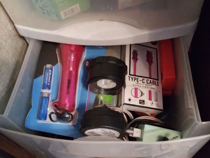 a full drawer of flashlights, batteries, cell phone charging cords.