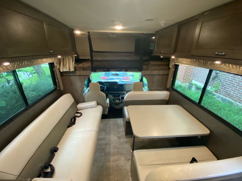 View of the dinette, couch and front of the coach (including bed above cab. 