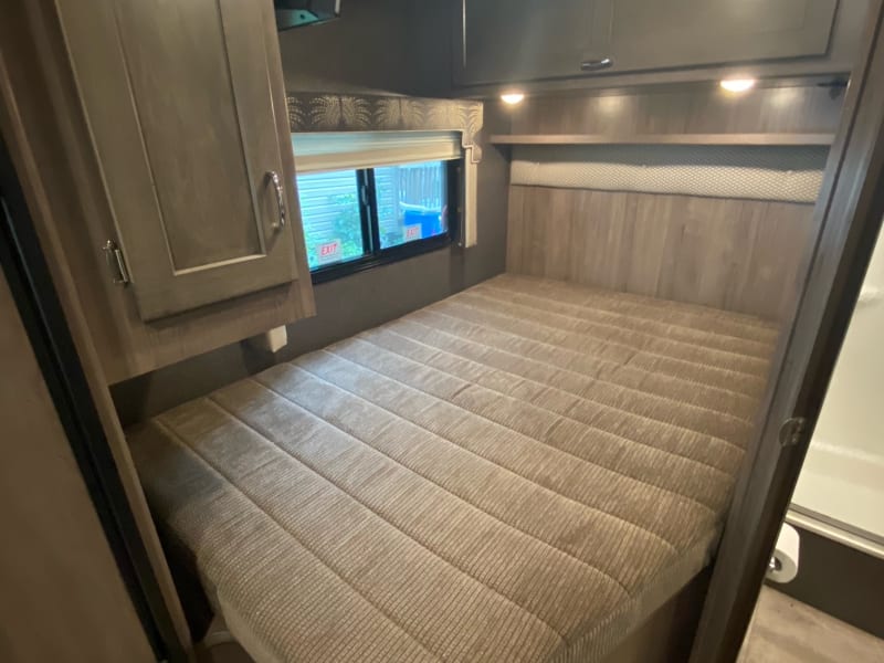 Queen bed in back of coach. Storage above the bed and small hanging closet at the foot of the bed. 