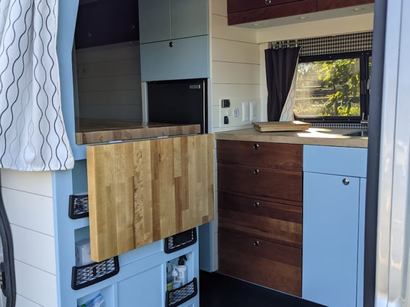 Extra storage and pop up work surface (opposite) converts to toilet room and shower.