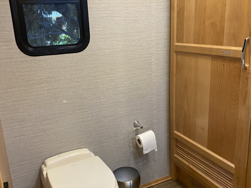 Master Bathroom with shower, sink/vanity, linen closet, toilet, and storage cabinet with tankless/endless hot water heater.