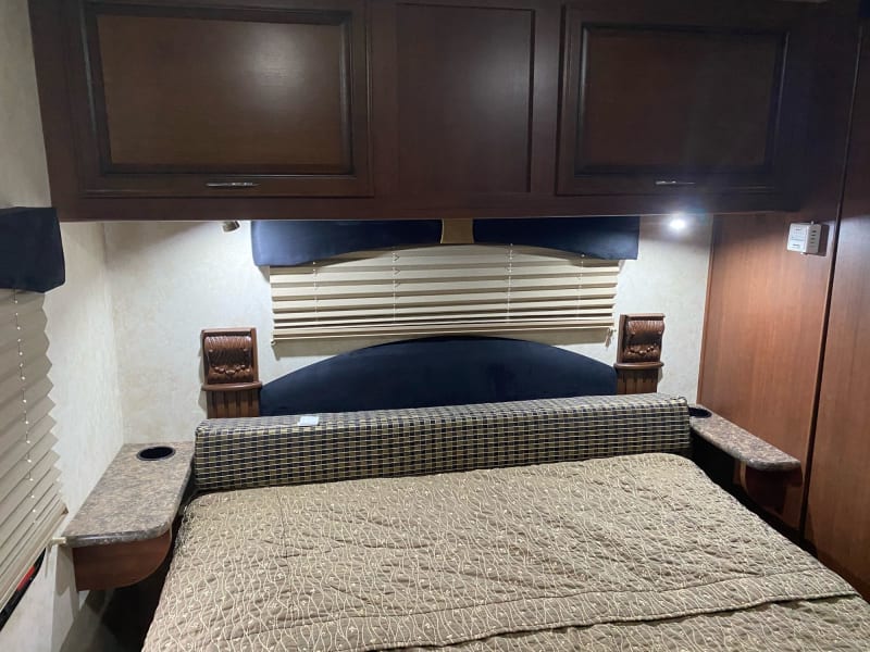 Queen bed in private bedroom with two night stands, storage underneath & above. 
