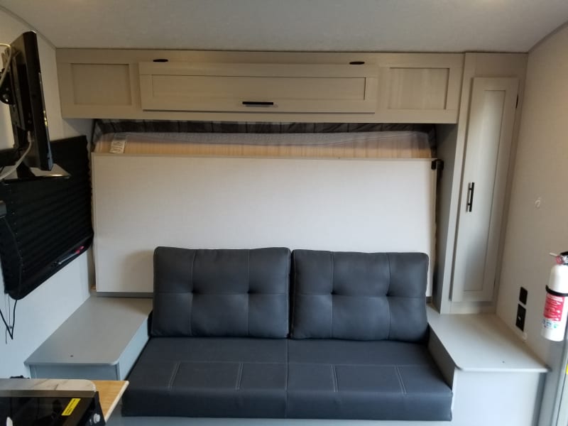 Family couch conversion from the queen mattress with included ottoman. Access to mounted monitor/ television.