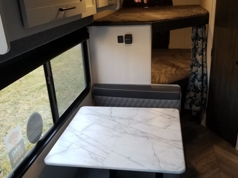 Family size dining table fitting for family meals and the view of your journey. Included view of full sized bunk bed in the rear.