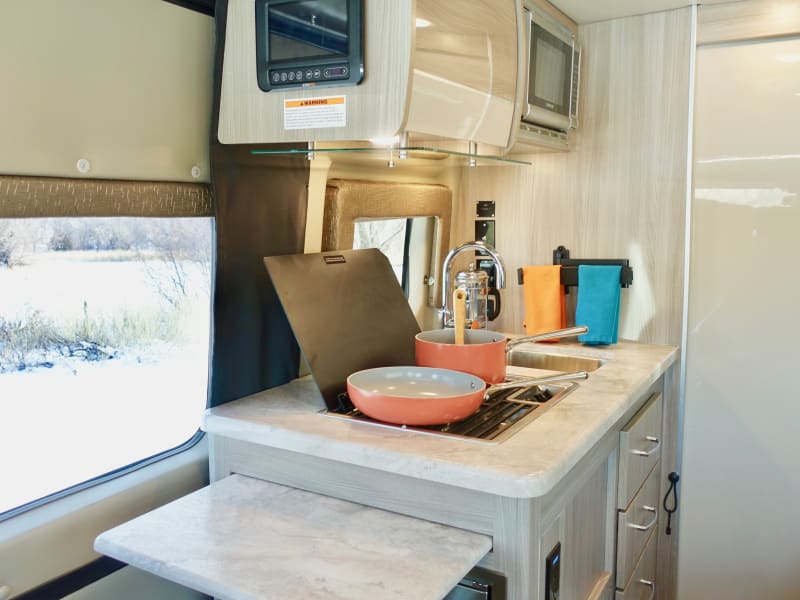 Dual gas burners, hot water, a fridge and a microwave make for an easy way to prepare your own gourmet camp food.