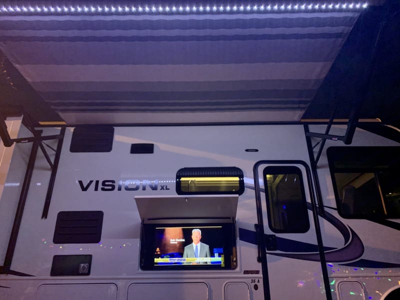 Passenger's side - outdoor TV, awning lights and awning.