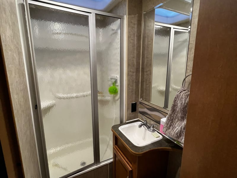 Spacious bathroom with large shower and cabinet. 