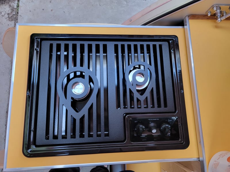 Pull out style galley propane cooktop with 2 burner stove with all pots and pans and dishes below ,even a waffle maker.